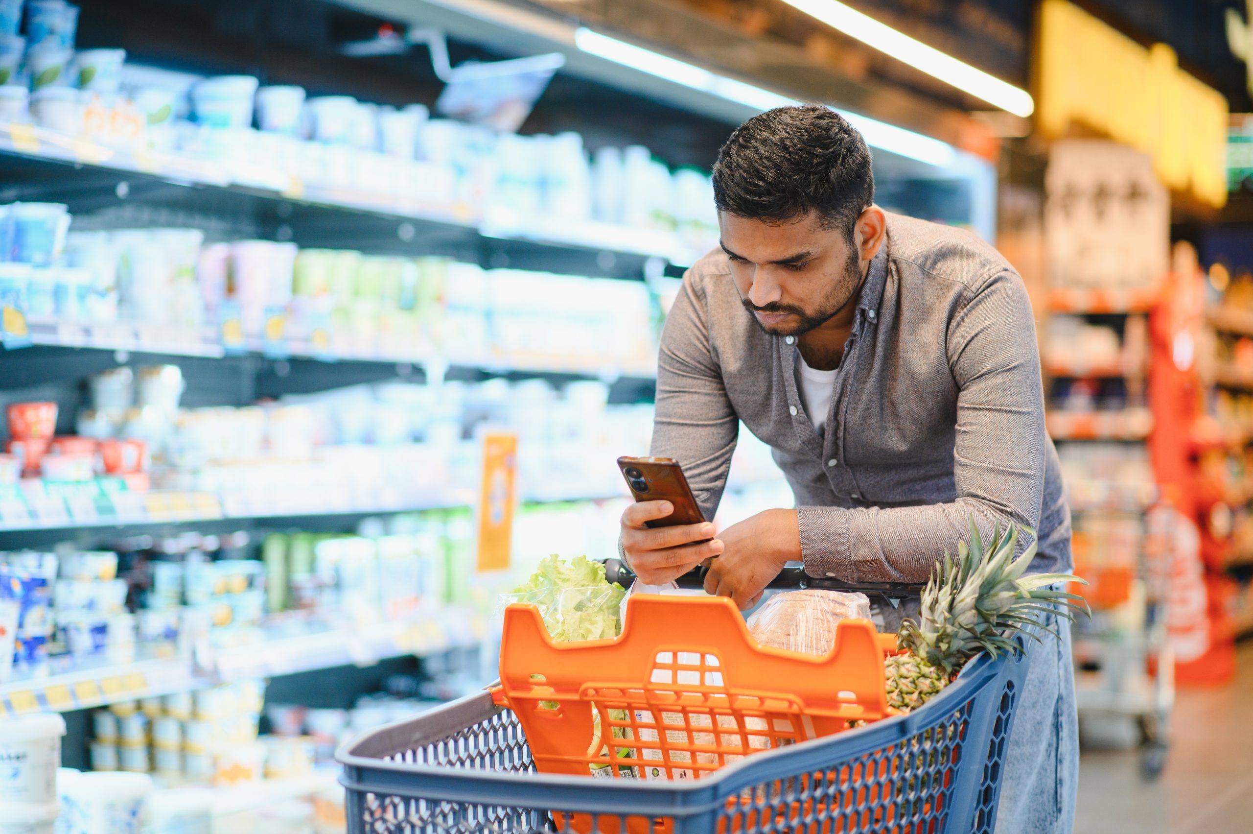 Male,Consumer,Comparing,Prices,And,Products,On,His,Phone,While
